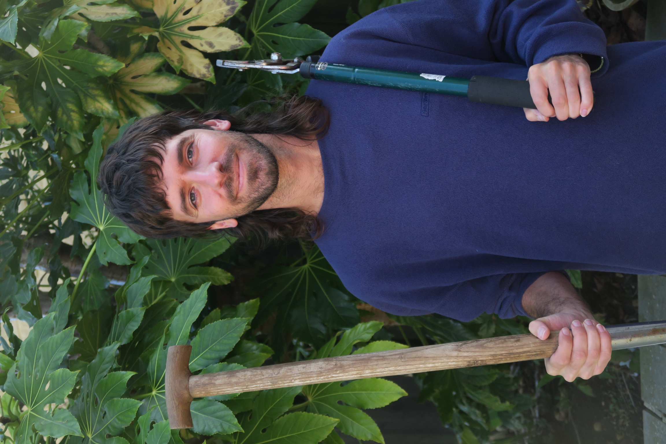 Oli smiling in front of a brick wall